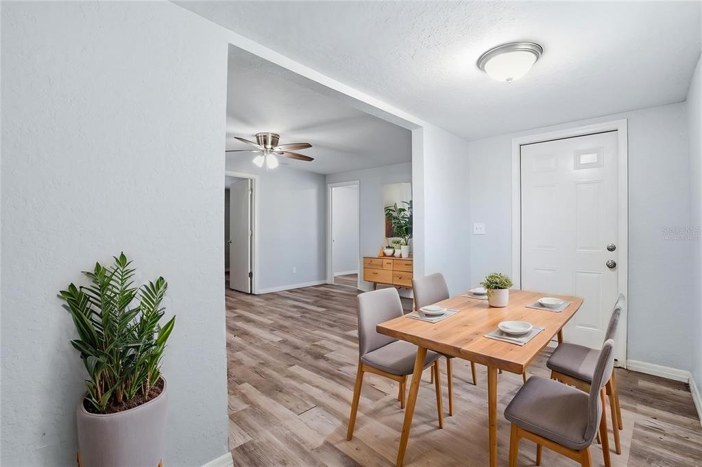 A dining area with a wooden table and chairs sits adjacent to an open living space — 2717 13TH AVENUE S, ST PETERSBURG, FL