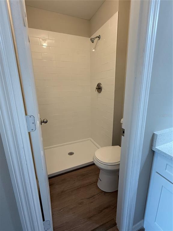 A bathroom features a walk-in shower with white subway tile and a white toilet — 39132 COUNTY ROAD 54 UNIT 2018, ZEPHYRHILLS, FL