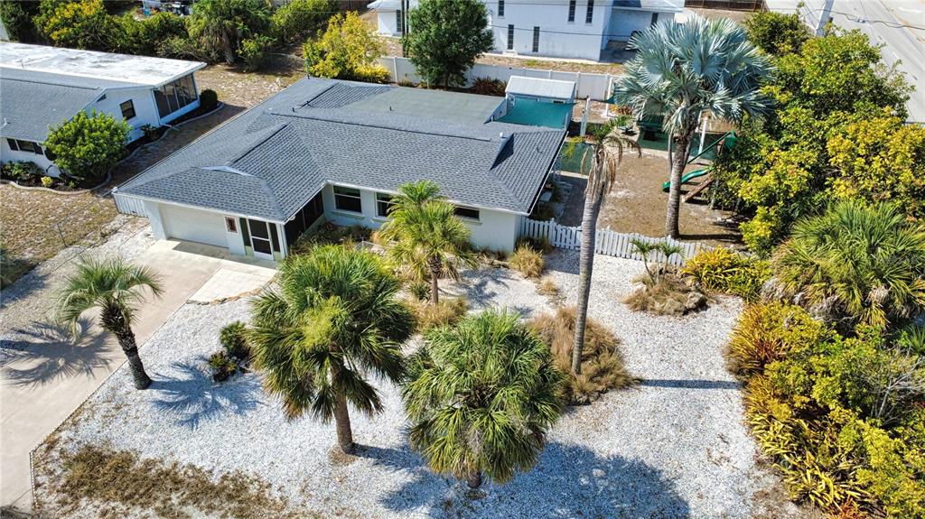 An aerial view shows a single-story house with a gray roof and a landscaped yard — 1 CAROLL CIRCLE, ENGLEWOOD, FL