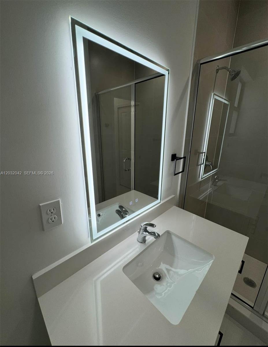 A modern bathroom features a white vanity, a rectangular vessel sink, and an illuminated mirror — 14429 SW 19th St # 1, Miami FL 33175, MIAMI, FL