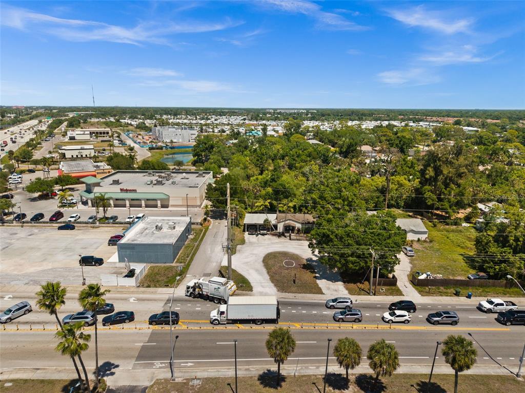 An aerial view shows a commercial area with a Walgreens, a house, and traffic on a road — 109 LAUREL ROAD E, NOKOMIS, FL