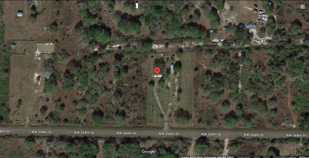 This satellite map view shows a house on a rural lot along a dirt road — 17383 NW 264TH STREET, OKEECHOBEE, FL