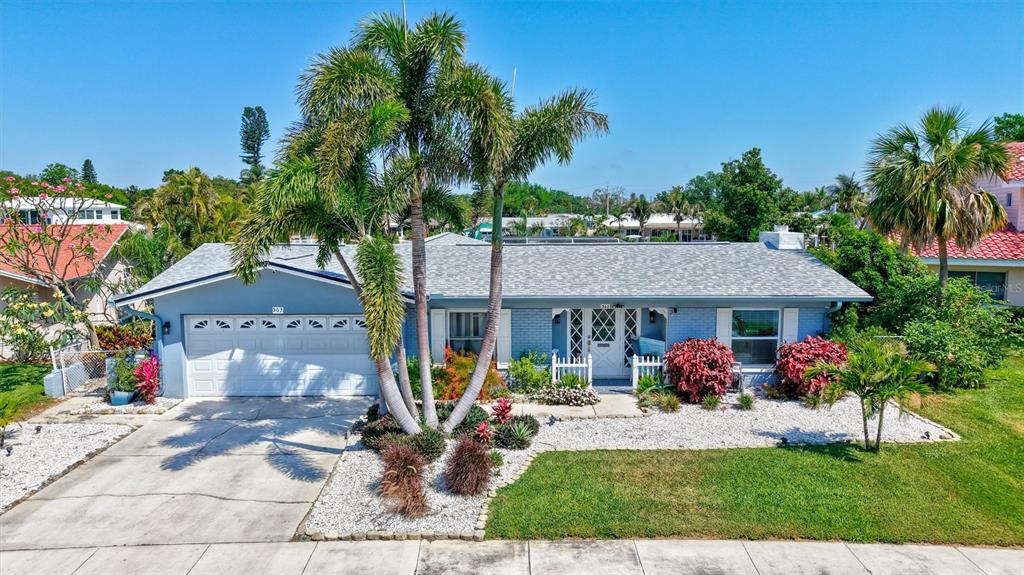 A single-story blue house with a white garage door and palm trees in the front yard — 563 LEWIS BOULEVARD SE, ST PETERSBURG, FL