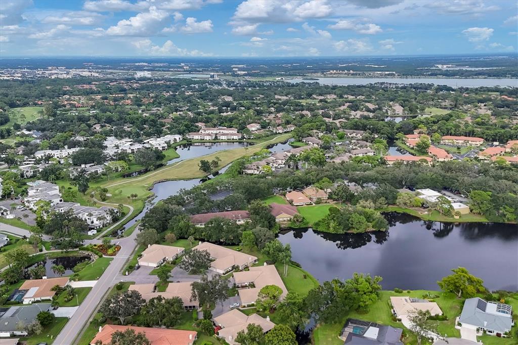 An aerial view shows a residential neighborhood with multiple ponds, green spaces, and paved roads — 3244 RINGWOOD MEADOW UNIT 77, SARASOTA, FL