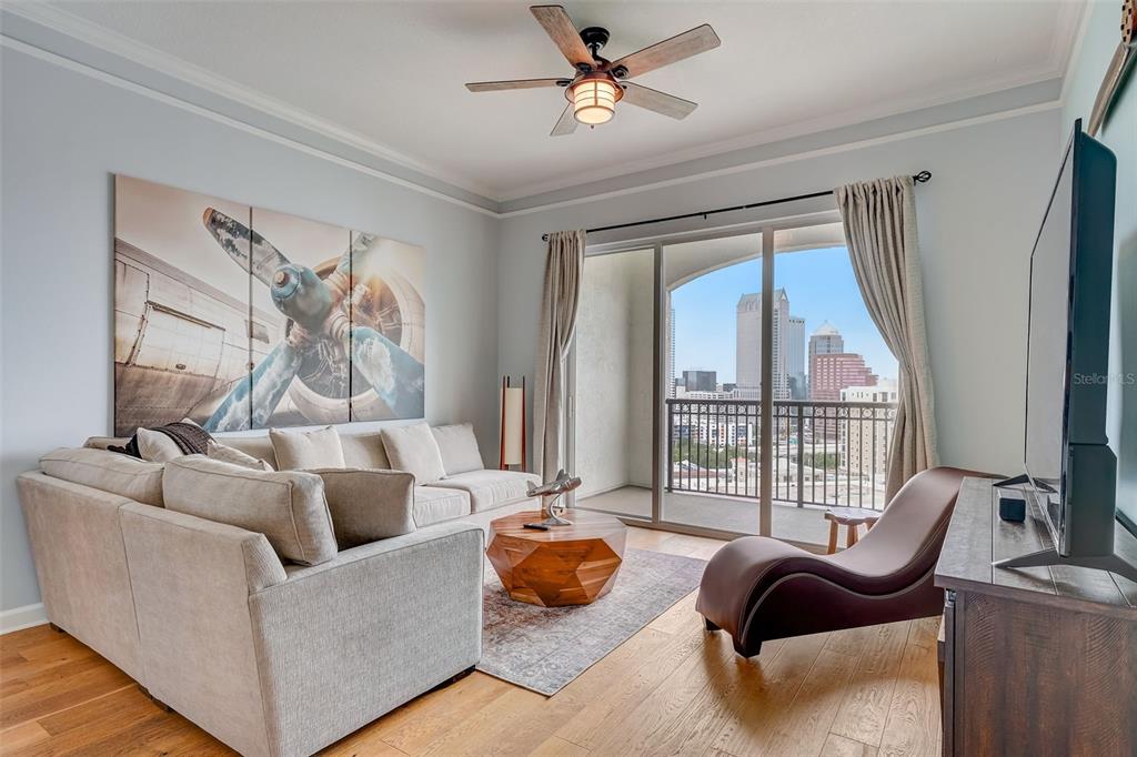 A living room features a sectional sofa, a geometric coffee table, and a city balcony view — 345 BAYSHORE BOULEVARD UNIT GP06, TAMPA, FL