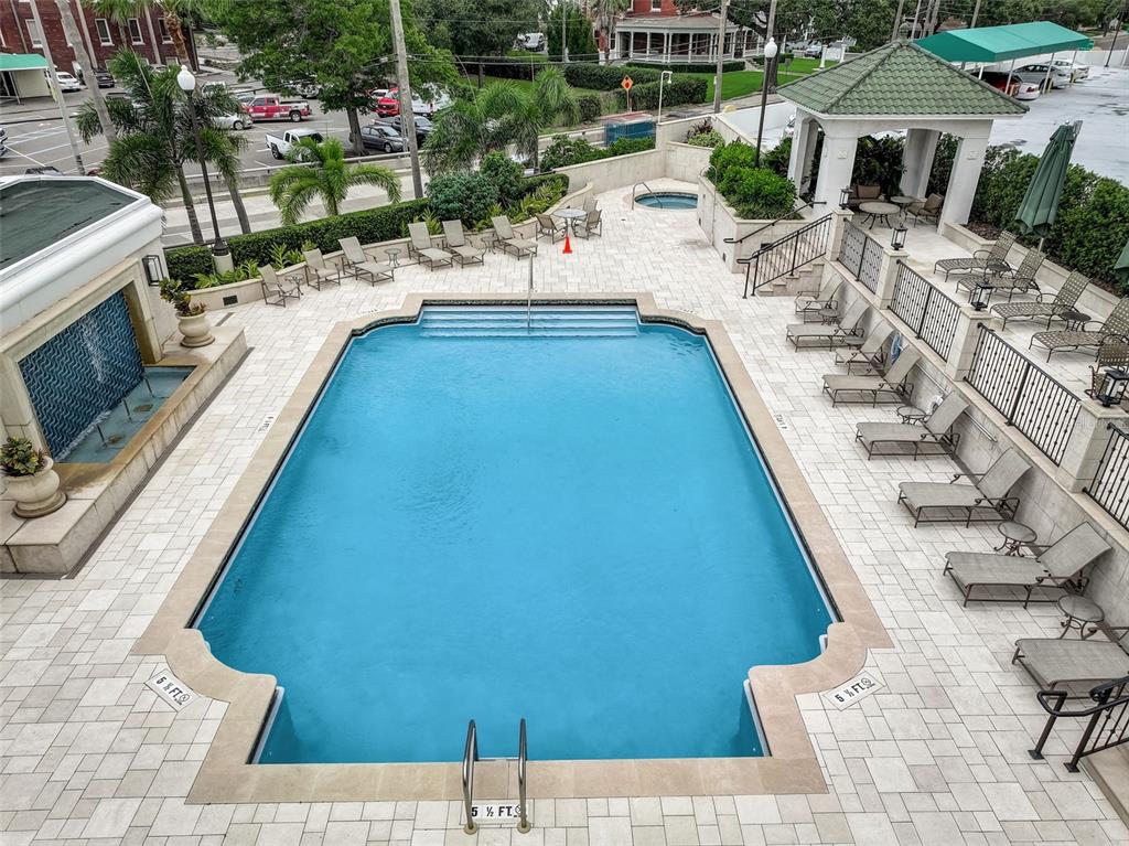 An elevated view of a rectangular swimming pool with a fountain and surrounding lounge chairs — 345 BAYSHORE BOULEVARD UNIT GP06, TAMPA, FL