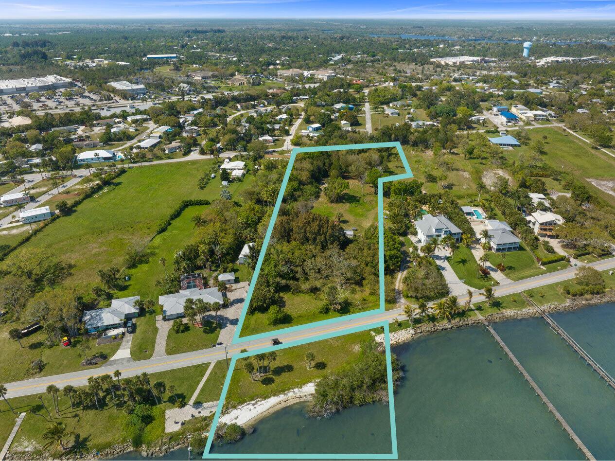 An aerial view shows a waterfront property outlined in blue, featuring land and a dock — SEBASTIAN, FL