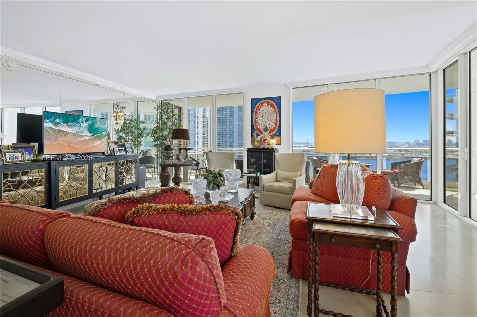 A living room features red patterned sofas, a glass-topped coffee table, and floor-to-ceiling windows — 901 Brickell Key Blvd # 2408, Miami FL 33131, MIAMI, FL