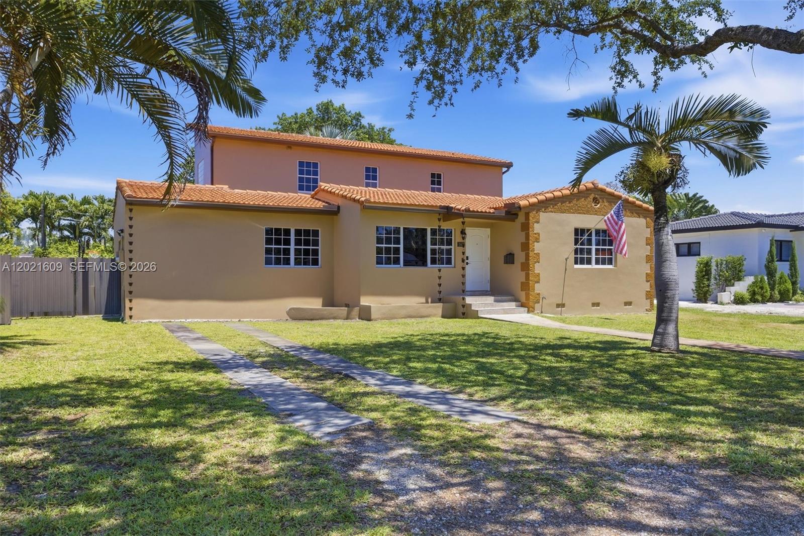 A two-story house with a tan stucco exterior, tile roof, and a front lawn — 245 Lenape Dr, Miami Springs FL 33166, MIAMI SPRINGS, FL