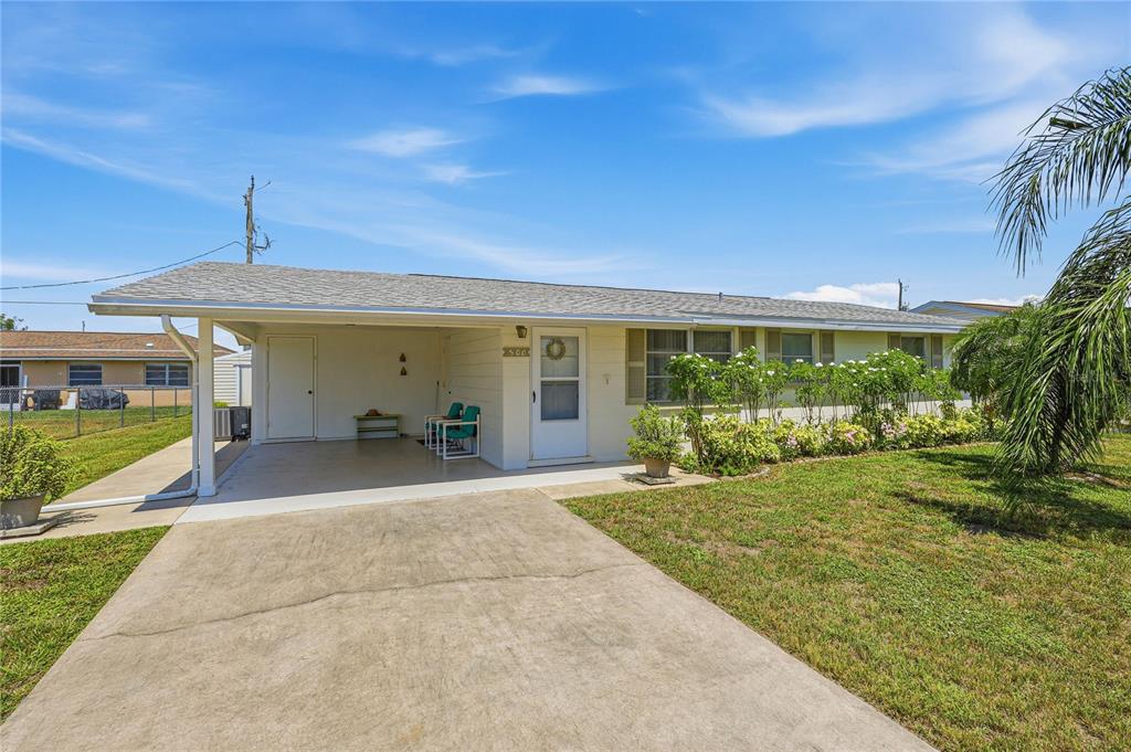 A single-story house with a concrete driveway, a carport, and a landscaped front yard — 300 SAN MARINO AVENUE, NORTH PORT, FL