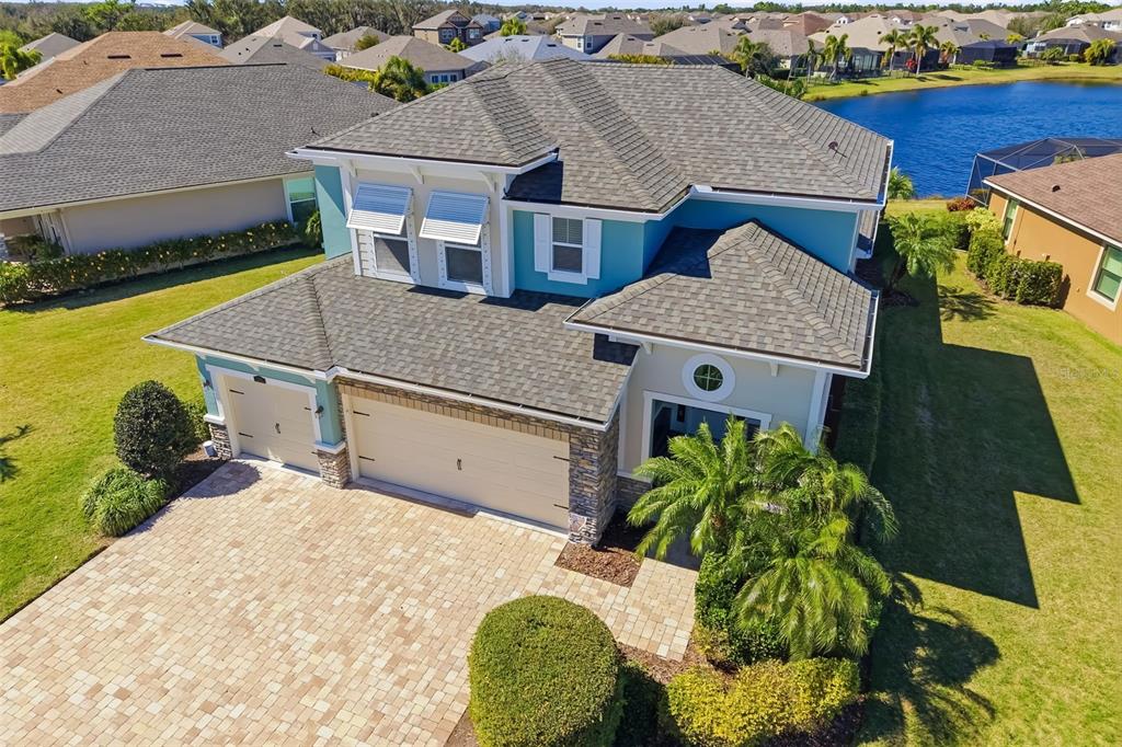 A screened-in patio overlooks a lake and palm trees from a paved outdoor area — 5315 BENTGRASS WAY, LAKEWOOD RANCH, FL