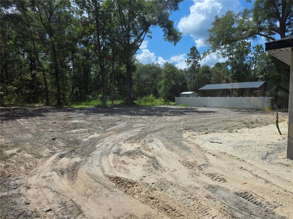 A cleared, sandy residential lot features tire tracks and is bordered by trees and fencing — 11491 NW 92ND CT, CHIEFLAND, FL
