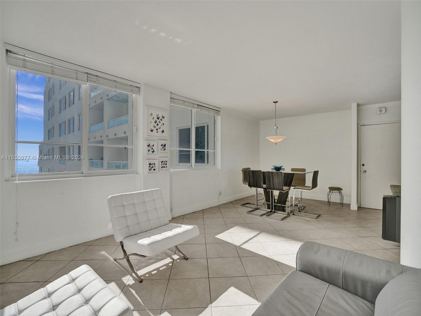 A bright living and dining area features tile floors, white walls, and ocean views — 5005 Collins Ave # 725, Miami Beach FL 33140, MIAMI BEACH, FL