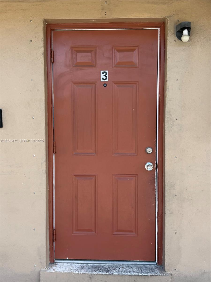 A brown exterior door labeled with the number three is set in a tan wall — 2924 NW 132nd Ter # 3, Opa-Locka FL 33054, OPA-LOCKA, FL