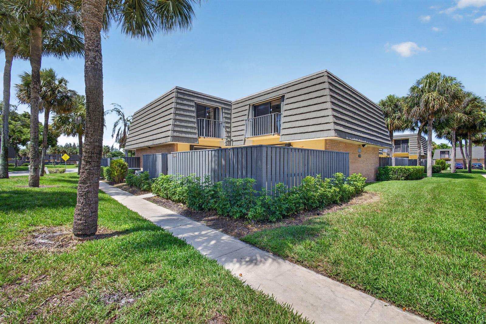 A two-story residential building with a gray mansard roof and a fenced-in patio area — 3501 35th Way, West Palm Beach FL 33407, WEST PALM BEACH, FL