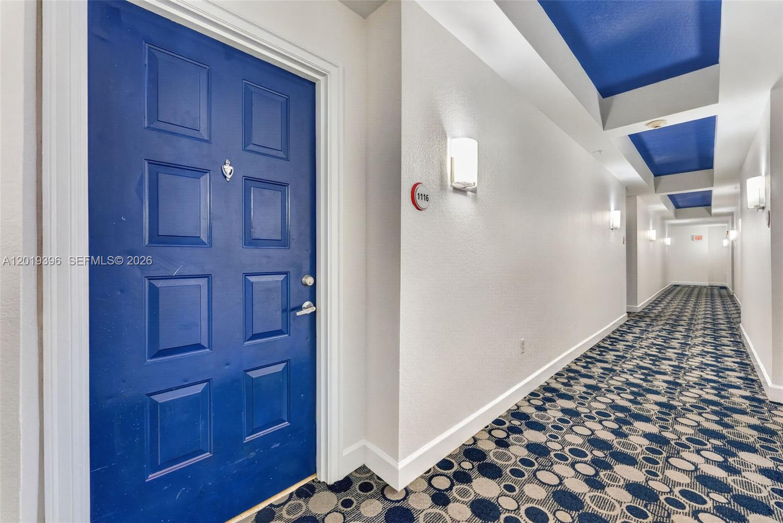 A blue door with a room number sign leads into a hallway with patterned carpeting — 1830 Radius Dr # 1116, Hollywood FL 33020, HOLLYWOOD, FL