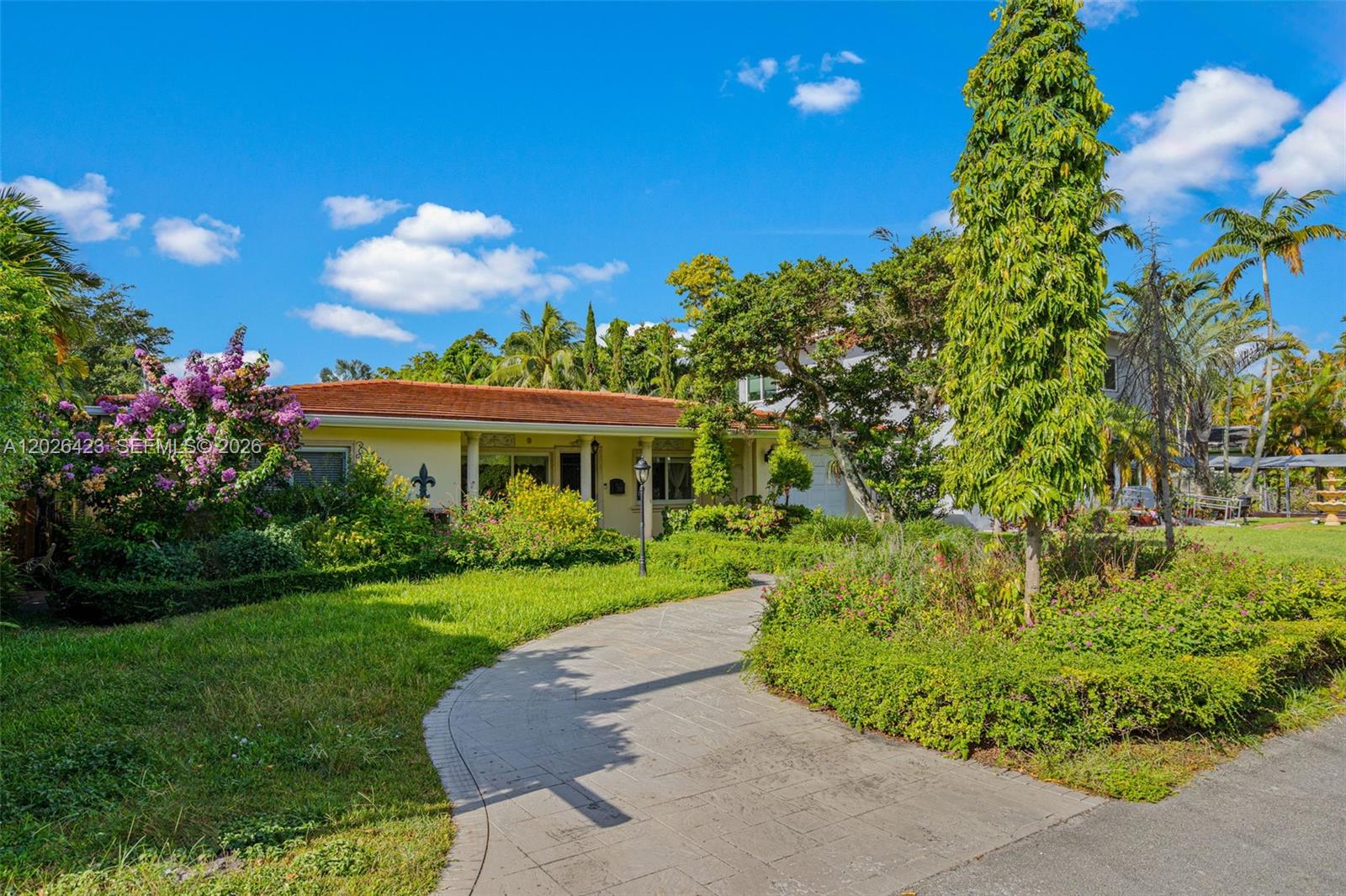A single-story house with a tiled roof and a curved stone walkway through the yard — 730 NE 116th St, Biscayne Park FL 33161, BISCAYNE PARK, FL
