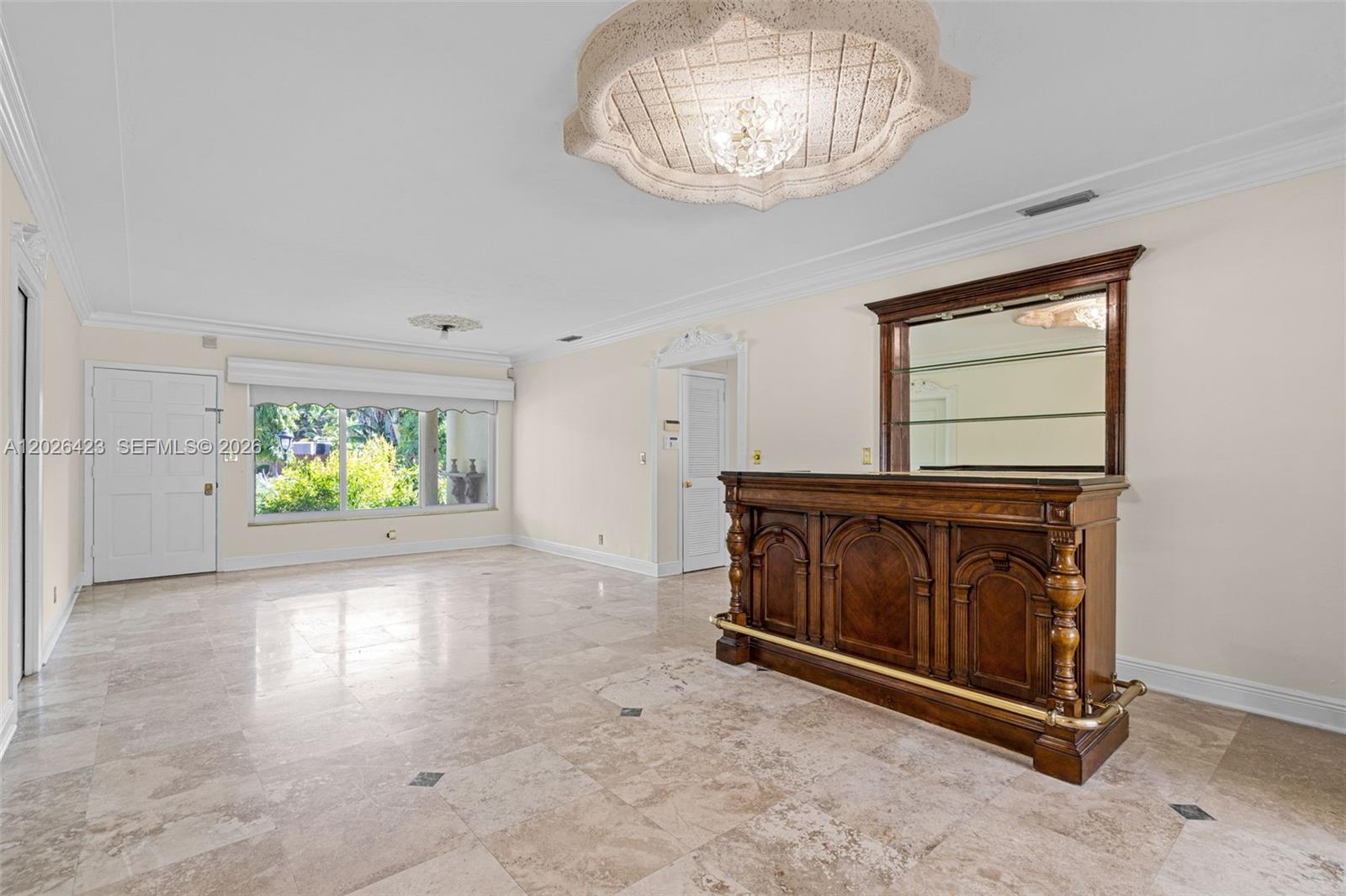 A room with tile flooring, a built-in wooden bar, and a decorative ceiling light fixture — 730 NE 116th St, Biscayne Park FL 33161, BISCAYNE PARK, FL
