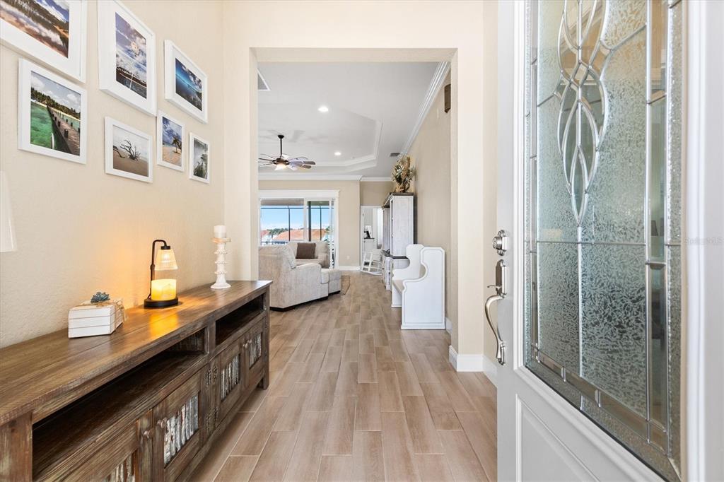 A wooden console table sits in a foyer with light wood-look tile flooring — 5105 JAREDS LANDING WAY, OXFORD, FL