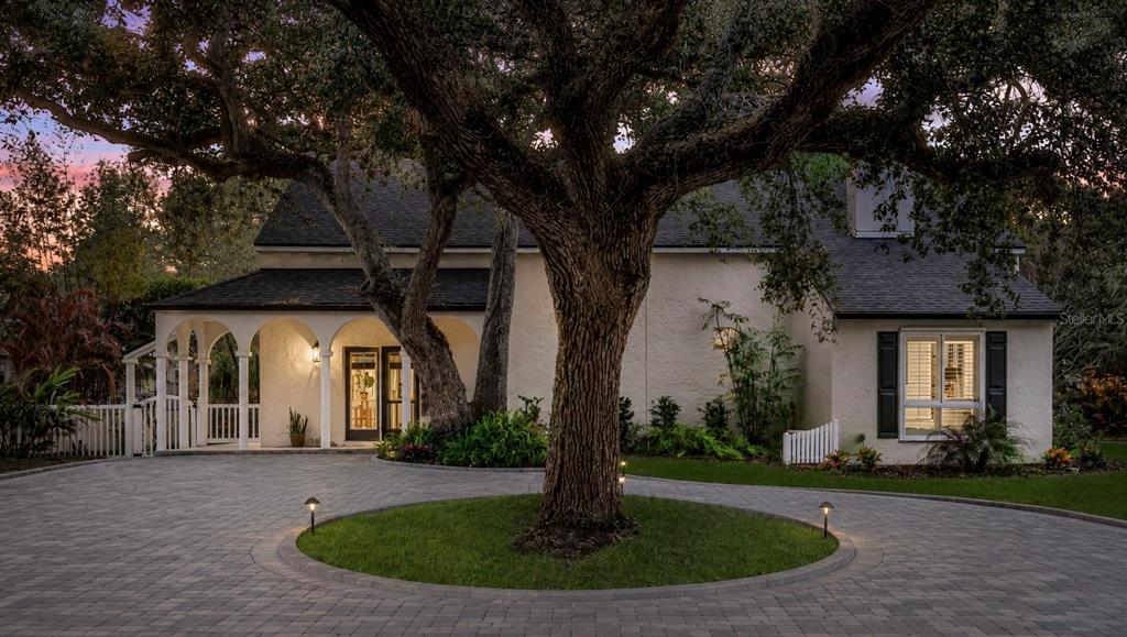 A house with a circular driveway and a large tree in the front yard — 111 ESTHER STREET, NEW SMYRNA BEACH, FL