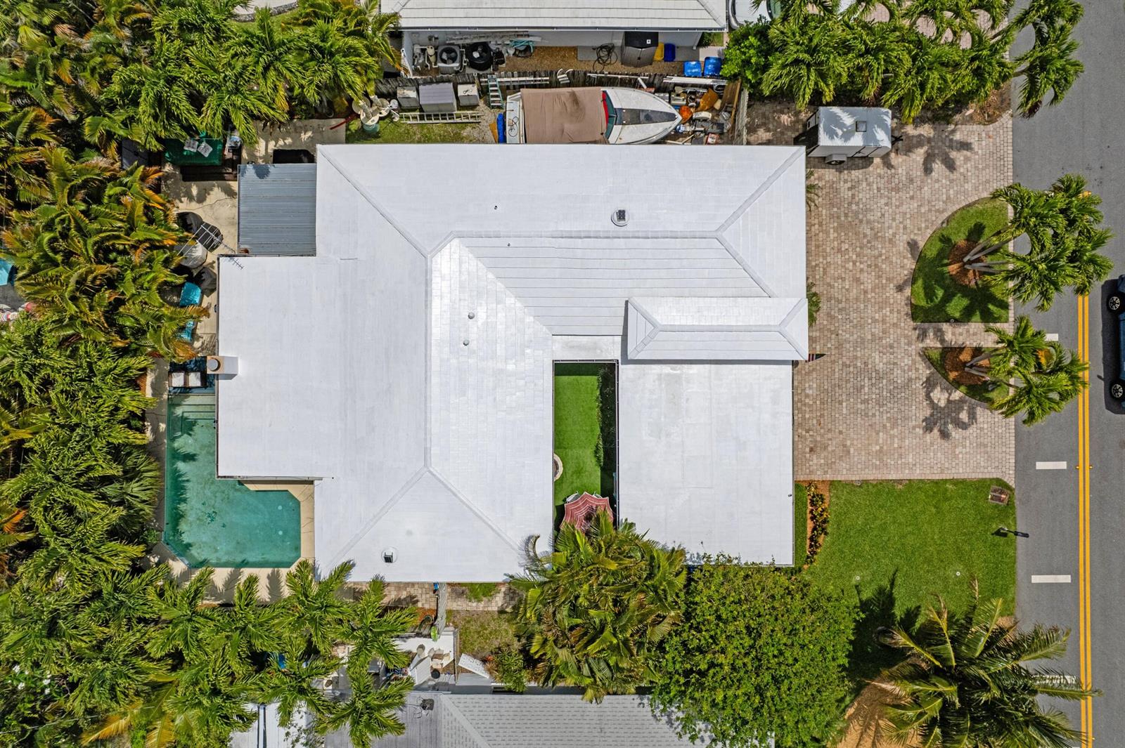 An aerial view shows a house with a white roof, a pool, and a courtyard — 1166 Beach Road, Singer Island FL 33404, SINGER ISLAND, FL