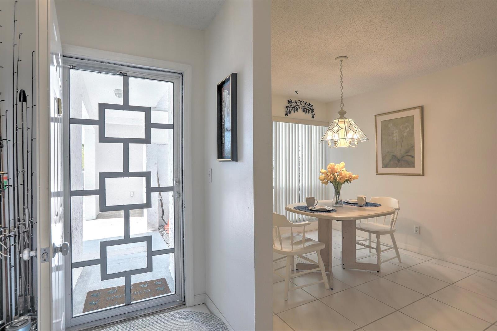A view from an entryway into a dining area with a round table and pendant light — SEBASTIAN, FL
