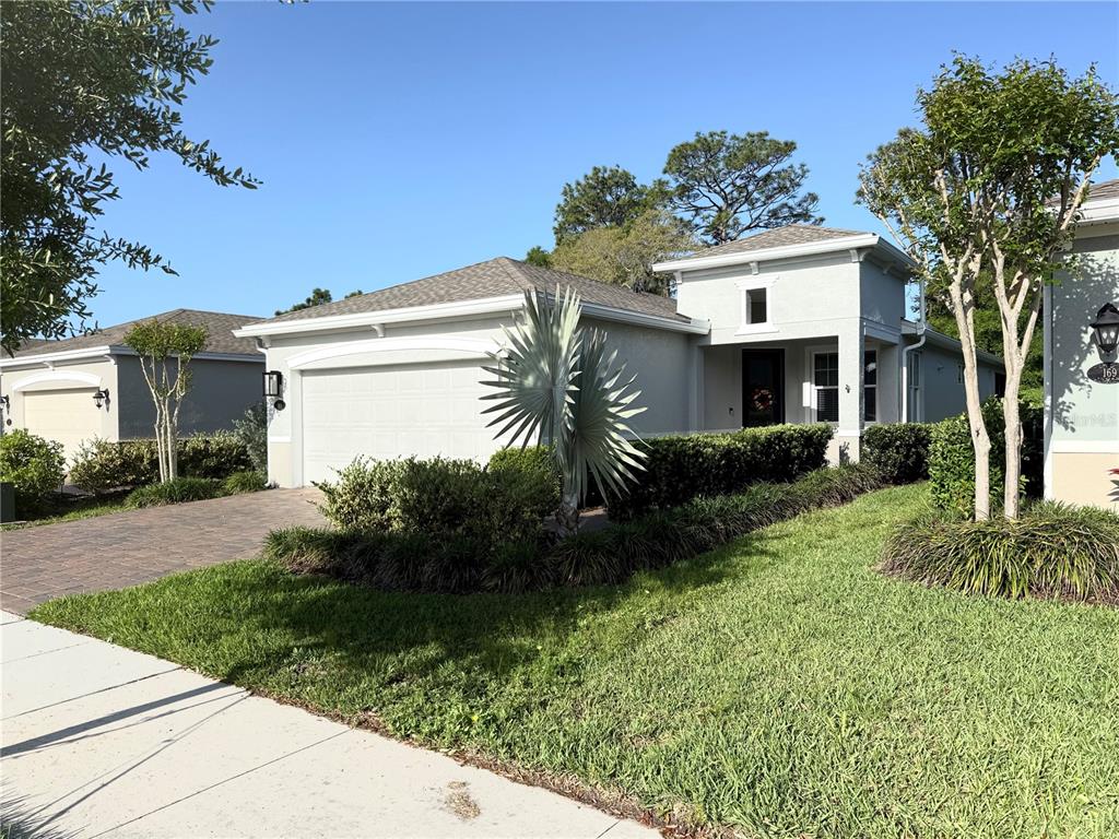 A single-story house with a two-car garage, a landscaped front yard, and a paved driveway — 173 OLD MOSS CIRCLE, DELAND, FL