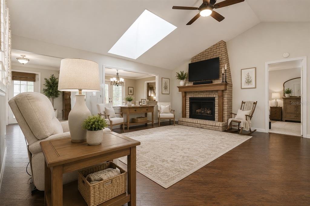 A living room features a brick fireplace, vaulted ceiling with a skylight, and hardwood floors — 5105 KEYSVILLE AVENUE, SPRING HILL, FL