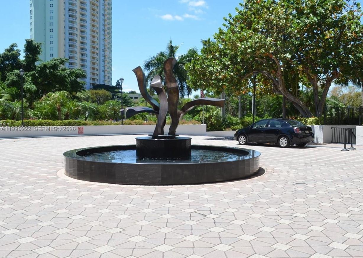 A circular fountain with a bronze abstract sculpture sits in a paved courtyard — 2333 Brickell Ave # 2607, Miami FL 33129, MIAMI, FL