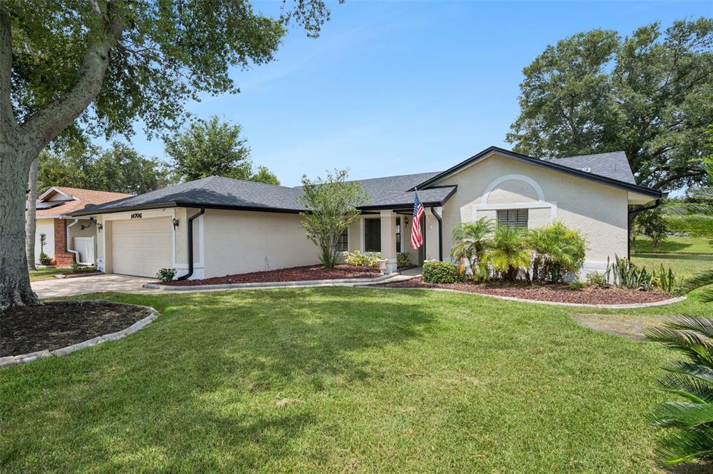 A single-story house with a beige stucco exterior, a two-car garage, and a front lawn — 14706 EAGLE VIEW COURT, ORLANDO, FL