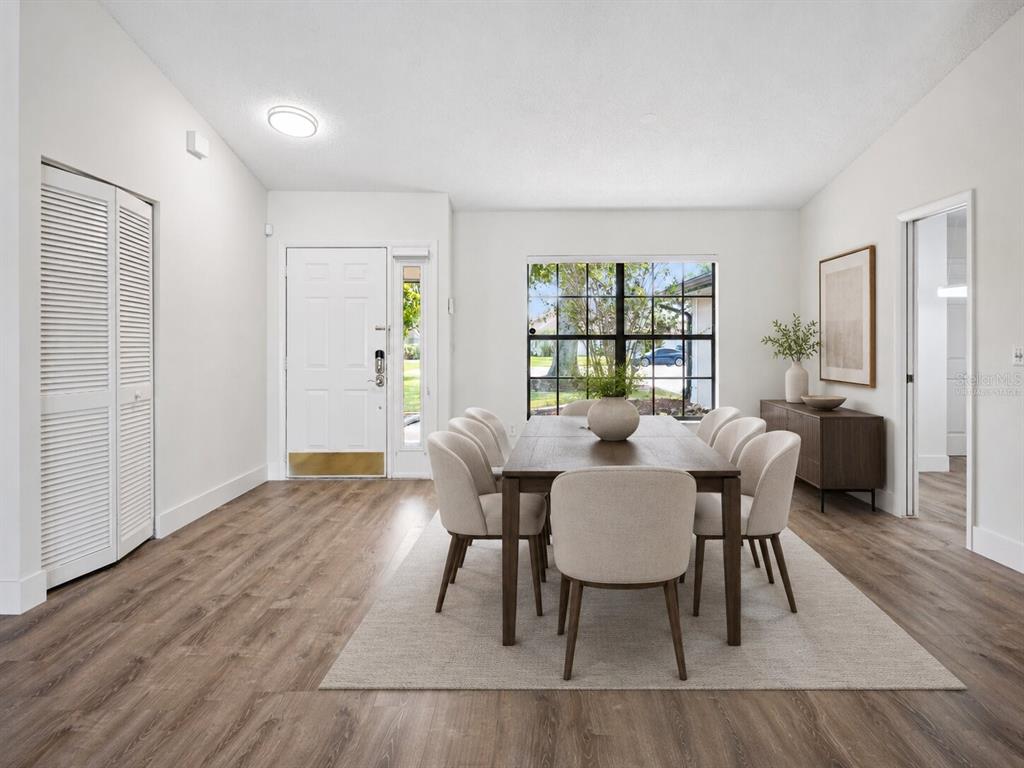 A dining room with a wooden table, six chairs, a rug, and a white front door — 14706 EAGLE VIEW COURT, ORLANDO, FL