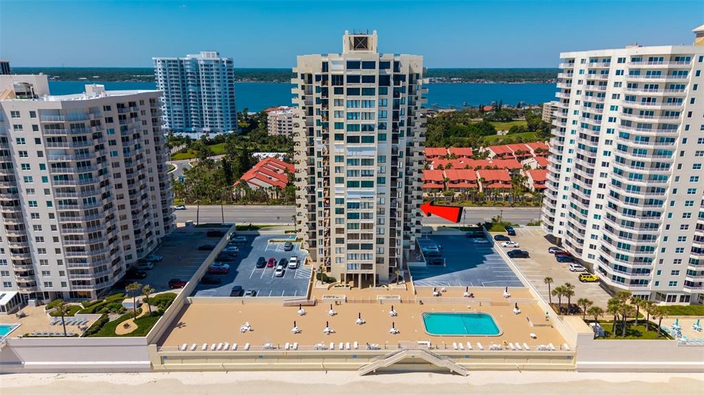 An aerial view of a beachfront high-rise condominium complex with a pool and parking lot — 2947 S ATLANTIC AVENUE UNIT 506, DAYTONA BEACH, FL