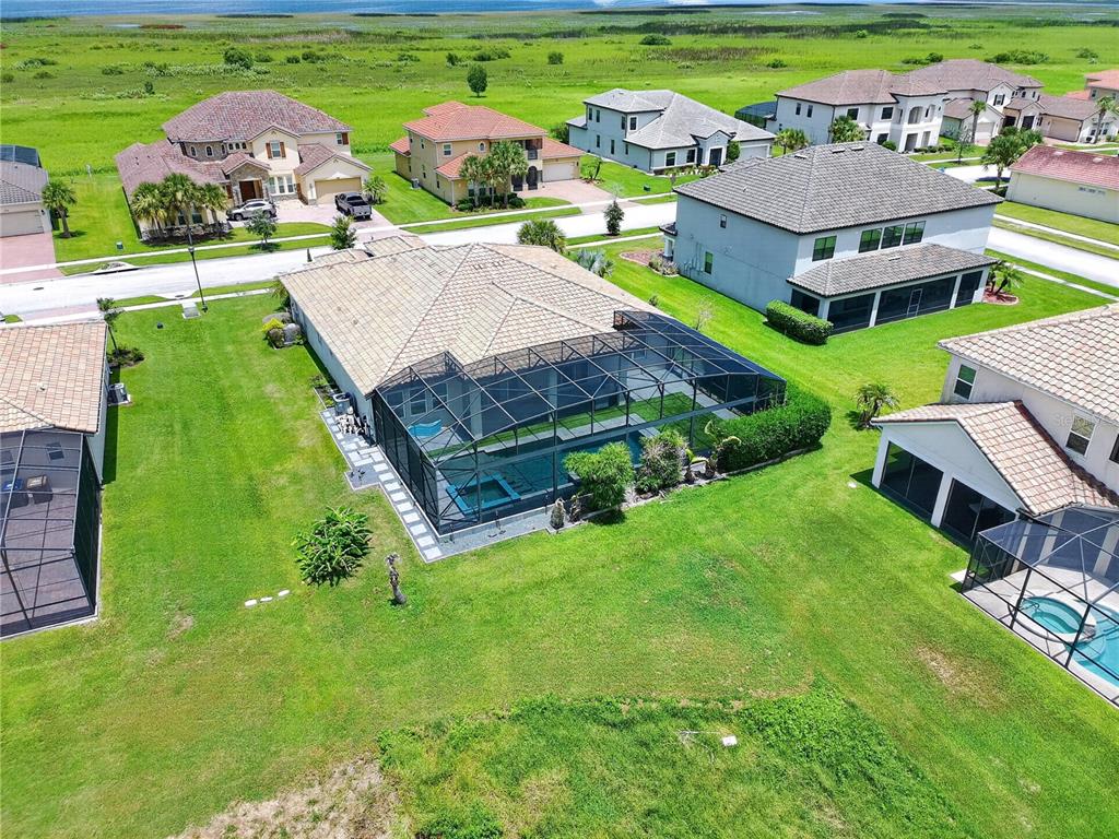 An aerial view of a suburban neighborhood featuring houses with screened-in pools and backyards — 781 WINDLASS COURT, KISSIMMEE, FL