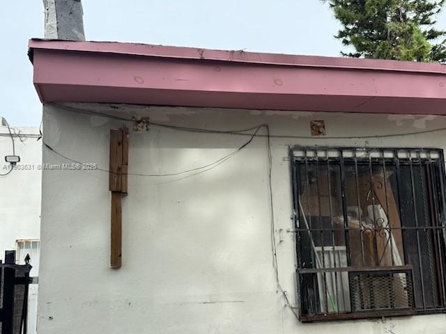 The exterior of a building features a pink fascia board and a barred window — 11628 NW 7th Ave, Miami FL 33168, MIAMI, FL