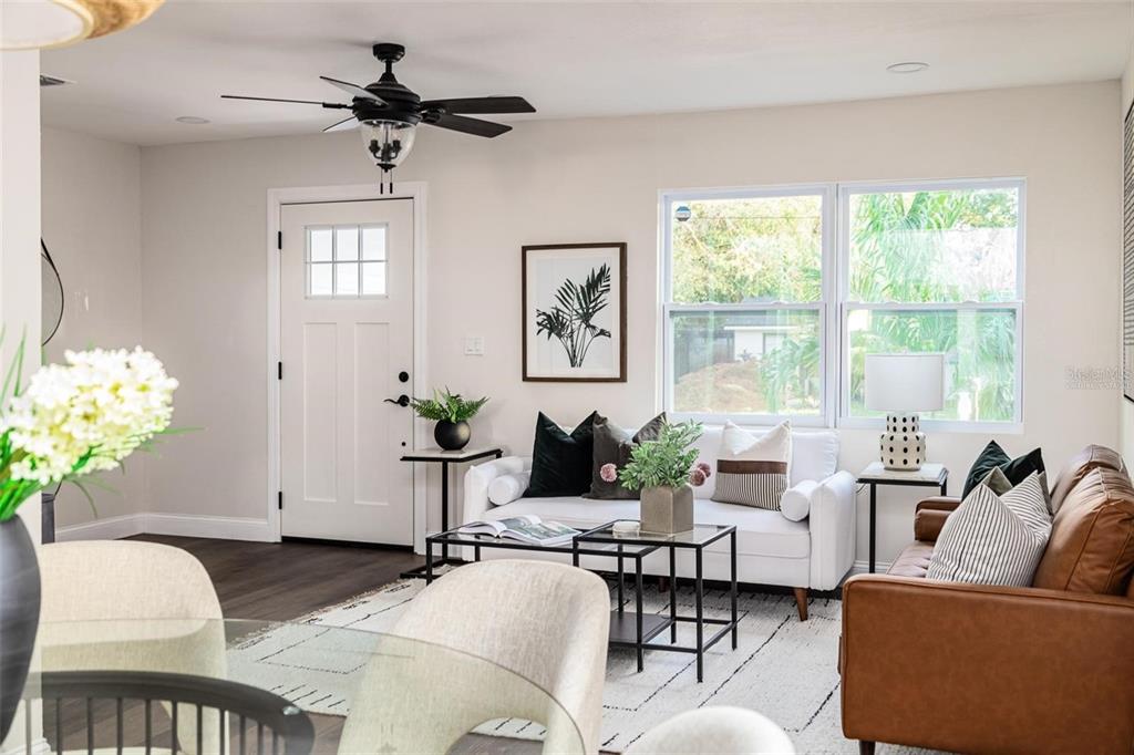 A living room features a white sofa, brown leather couch, and a ceiling fan — 1008 E NORFOLK STREET, TAMPA, FL