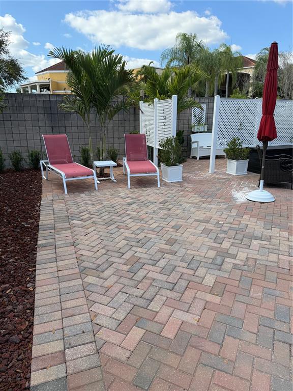 A paved patio features two lounge chairs, a small table, and white privacy screens — 6731 AMANDA VISTA CIRCLE, LAND O LAKES, FL