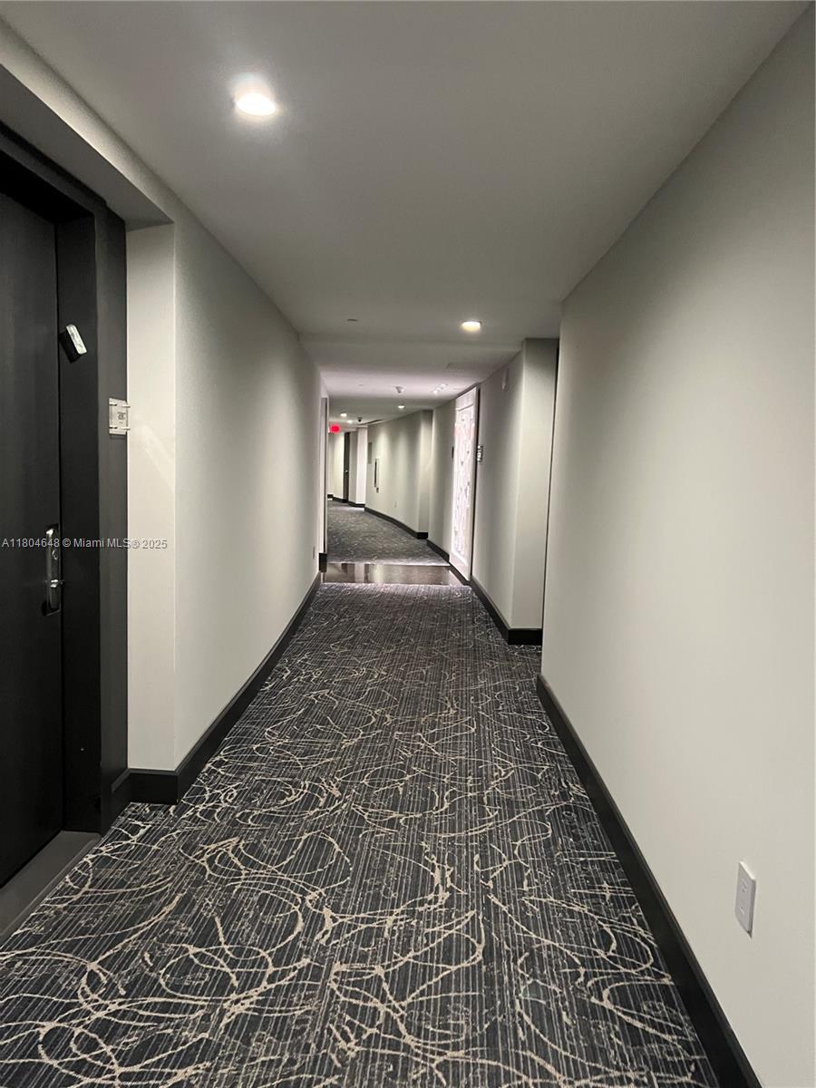 A long, narrow hallway features patterned gray carpeting, light-colored walls, and recessed ceiling lighting — 1800 S Ocean Dr # 2006, Hallandale Beach FL 33009, HALLANDALE BEACH, FL
