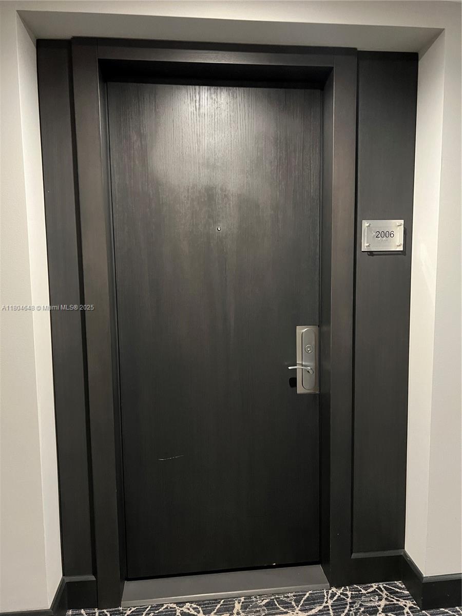 A dark wood door with a silver handle and a unit number sign 2006 — 1800 S Ocean Dr # 2006, Hallandale Beach FL 33009, HALLANDALE BEACH, FL