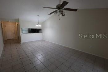 An open-concept living area features light-colored tile flooring, a vaulted ceiling, and a ceiling fan — 1155 THAYER STREET, SAFETY HARBOR, FL