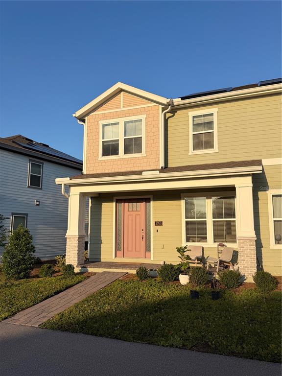 A two-story house with light green siding, a pink front door, and a brick walkway — 2953 VOYAGER AVENUE, ST CLOUD, FL