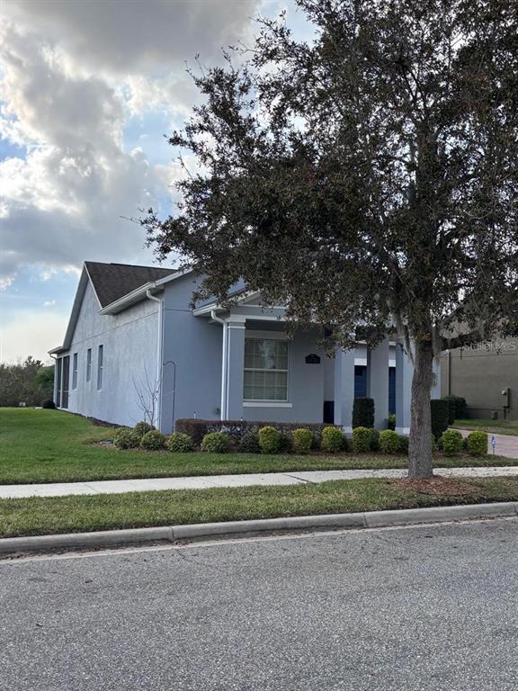 A light blue single-story house with a front porch and a large tree in front — 14719 SPEER LAKE DRIVE, WINTER GARDEN, FL