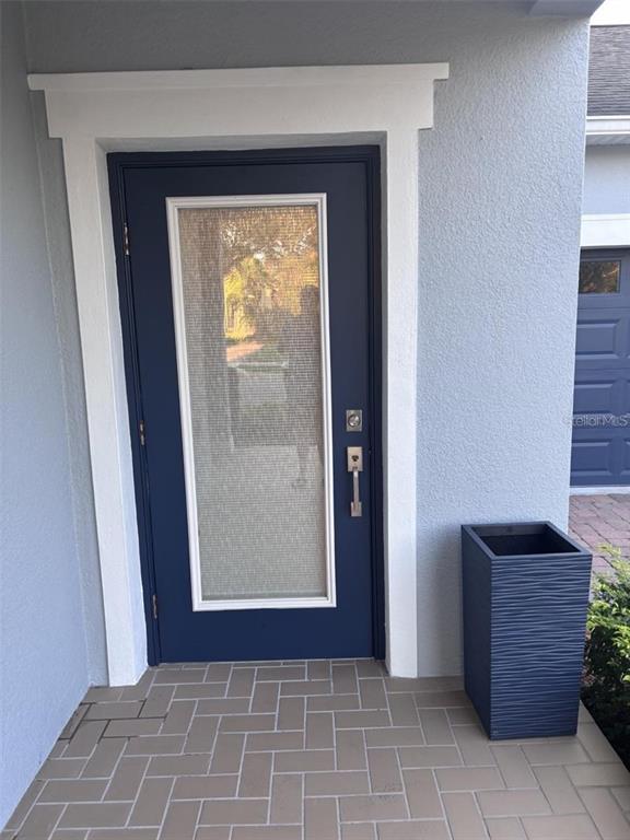 A blue front door with a glass panel and a matching planter on a porch — 14719 SPEER LAKE DRIVE, WINTER GARDEN, FL