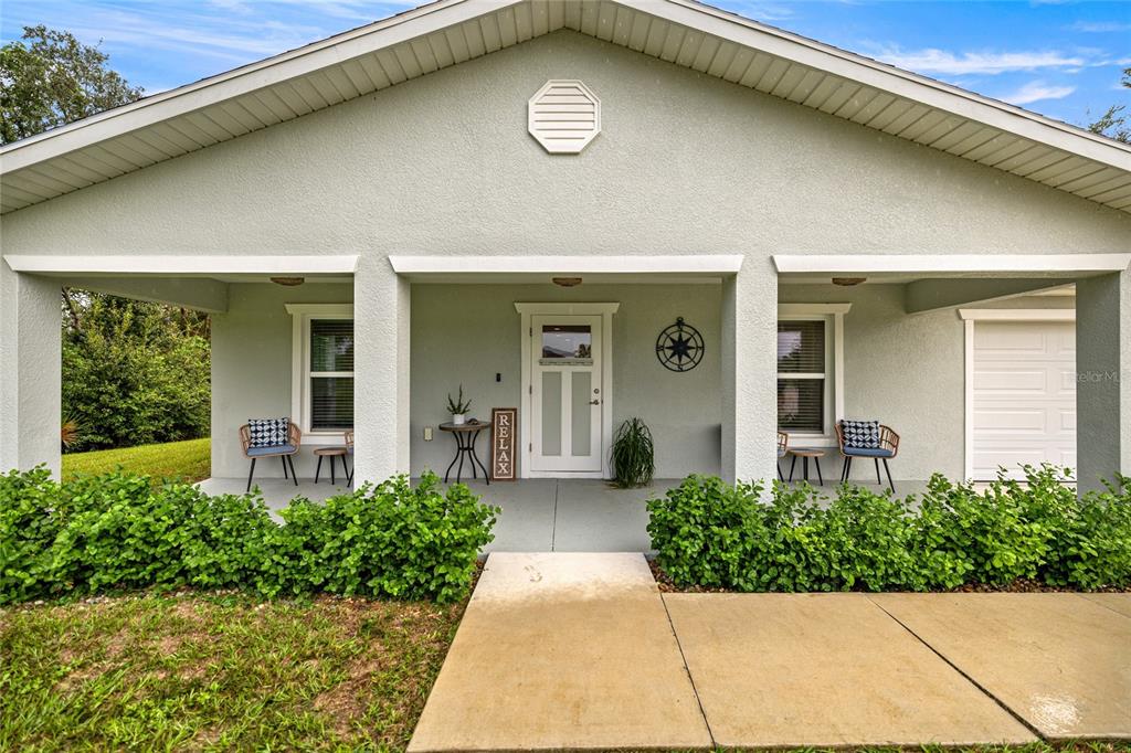 The exterior of a single-story house features a covered front porch with a concrete walkway — 53 OLIVE ROAD, OCALA, FL
