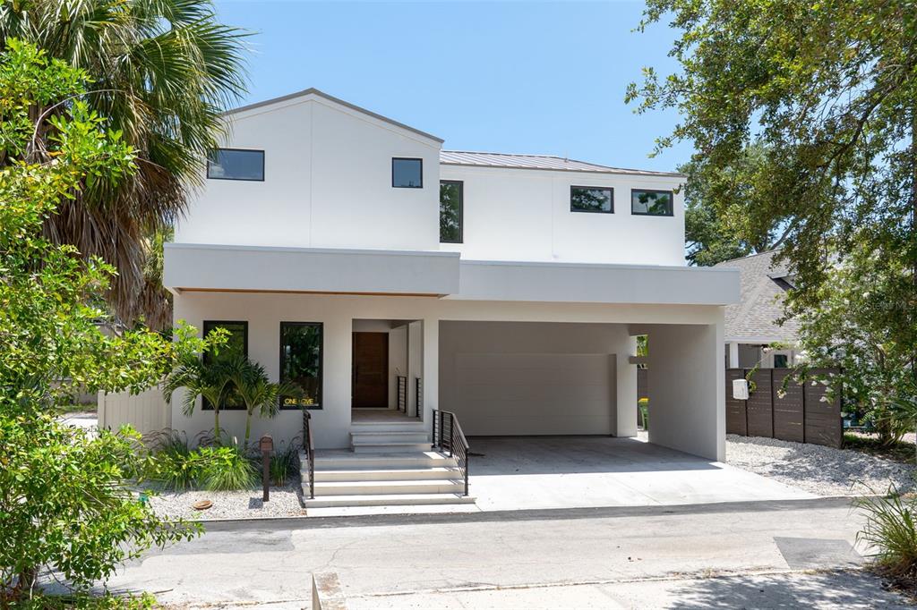 A modern two-story house with a white exterior, a flat-roofed carport, and front steps — 1680 CHERRY LANE, SARASOTA, FL