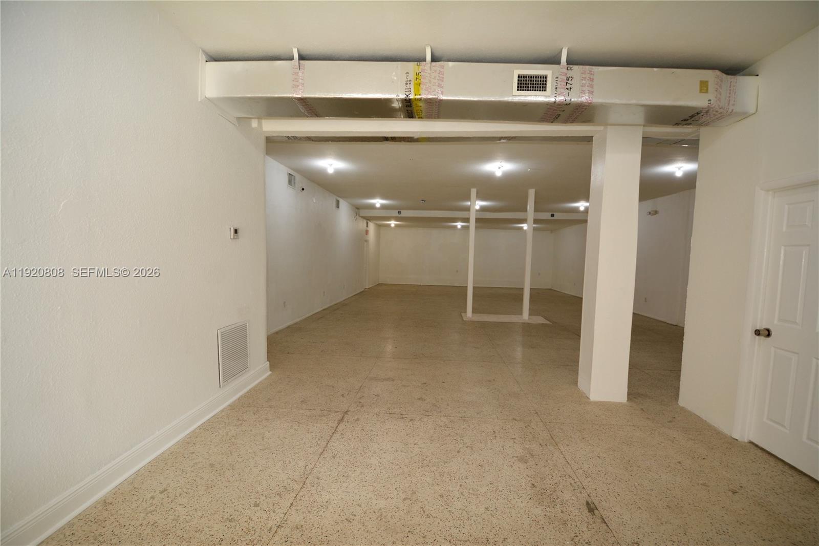 An unfinished basement features a concrete floor, exposed ductwork, and white support columns — 5525 NW 7th Ave, Miami FL 33127, MIAMI, FL