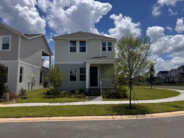 A two-story house with light gray siding and a front porch under a blue sky — 392 OAK FLAT ALLEY, GROVELAND, FL