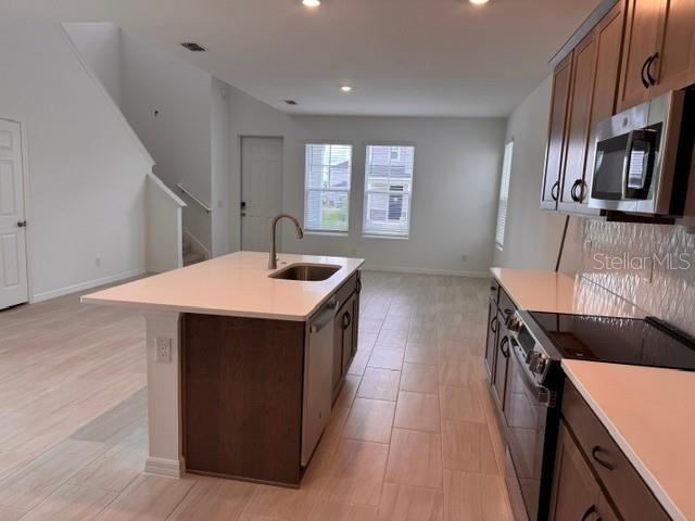 A kitchen with a central island, light tile flooring, and dark wood cabinetry — 392 OAK FLAT ALLEY, GROVELAND, FL