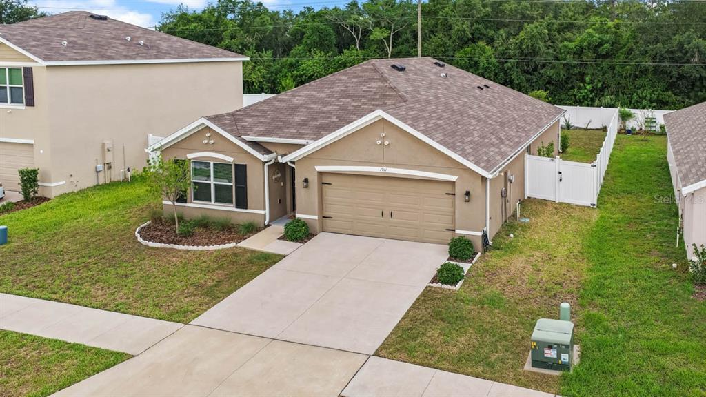 An aerial view of a single-story tan house with a two-car garage and driveway — 1911 BLUE STREAM STREET, RUSKIN, FL