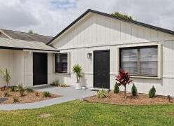 A single-story house with white vertical siding, black doors, and a large window — 8731 Uranus Terrace, West Palm Beach FL 33403, WEST PALM BEACH, FL