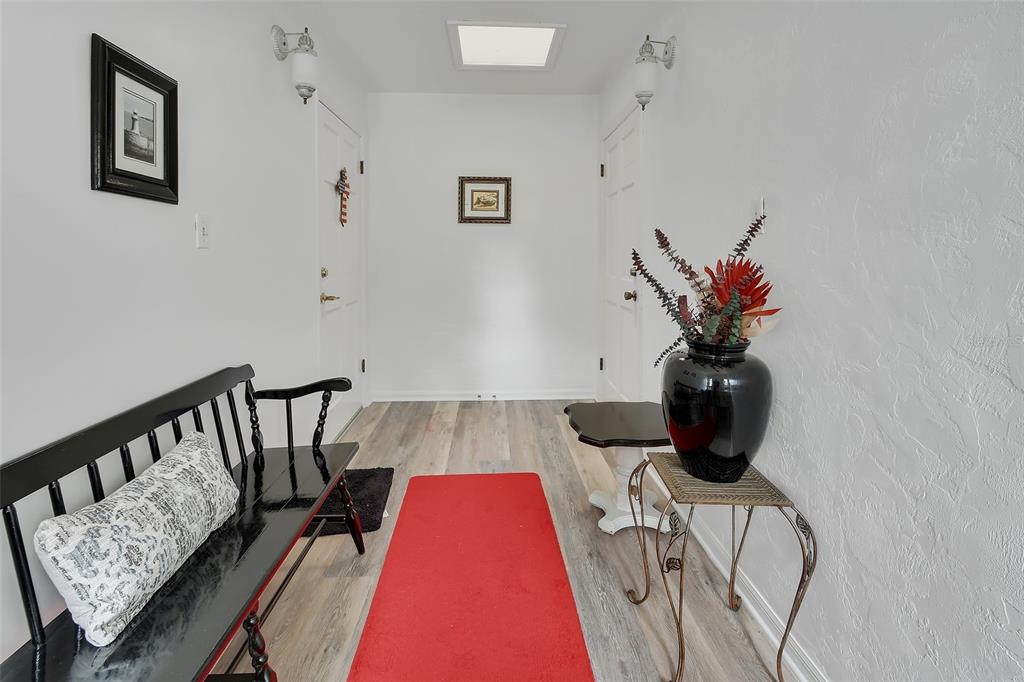 A bright entryway features white walls, wood-look flooring, a black bench, and a red runner — 720 S HILL AVENUE UNIT 8B, DELAND, FL